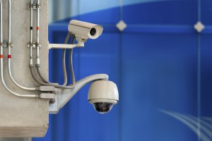 3 CCTV camera or surveillance operating on blue wall bakcground