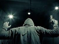 Man in hood, with gun surrender.